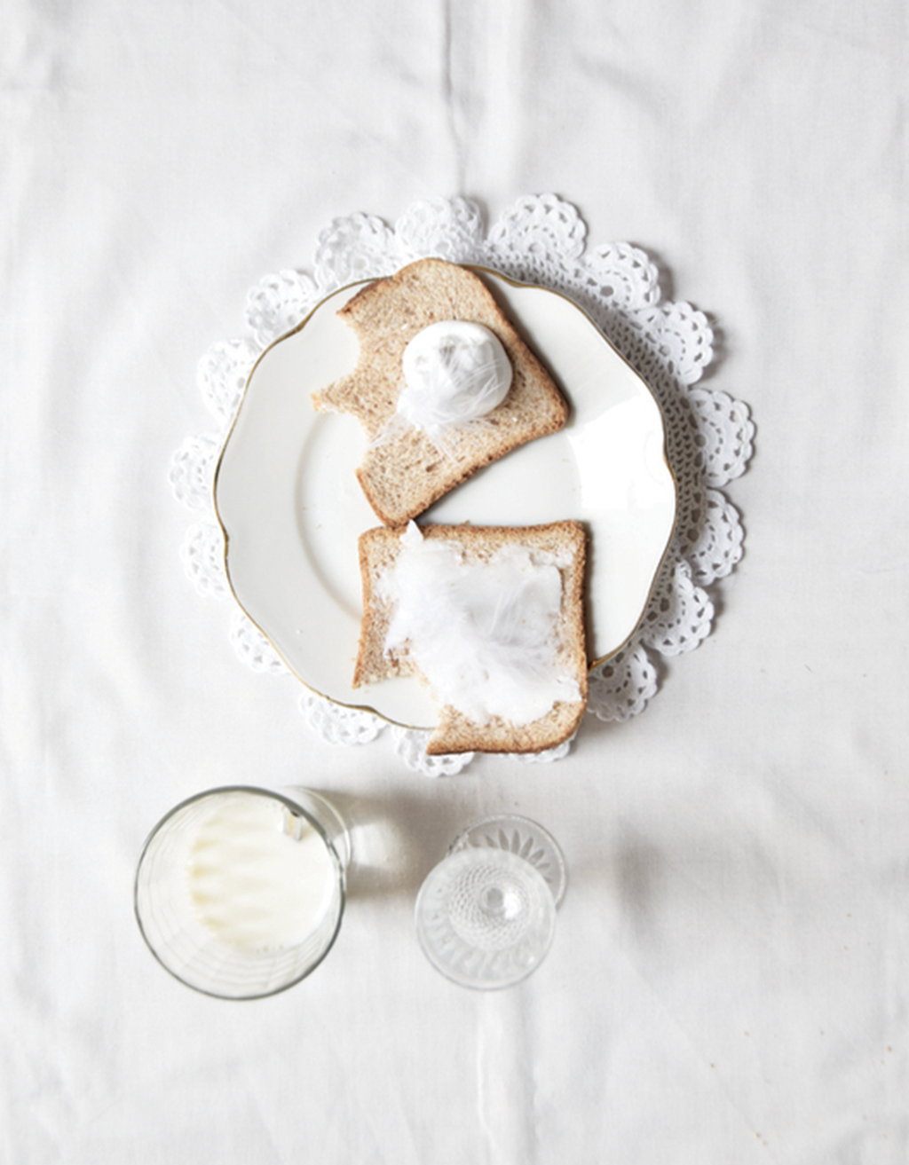 White background with two pieces of sandwich and a glass of milk